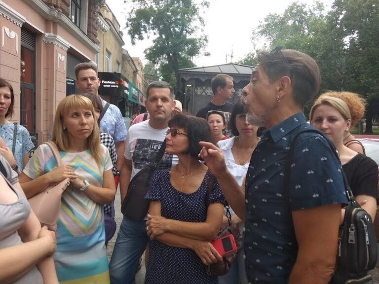 Экскурсия по Ильфу и Петрову в Одессе — гид рассказывает, участники слушают на городской улице